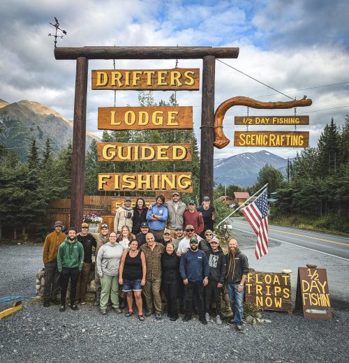 Employees standing by Drifters Lodge sign